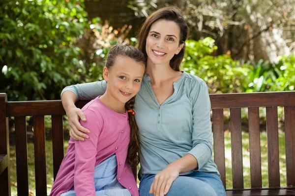 Donna e figlia seduta su una panchina di legno — Foto Stock