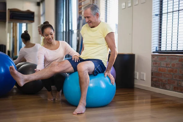 Terapeut pomáhá starší pacient dělat cvičení — Stock fotografie