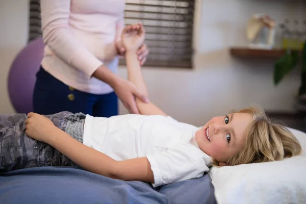 Gosse medan terapeuten undersöker arm — Stockfoto