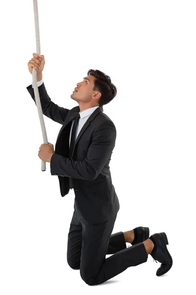 Hombre de negocios tirando de la cuerda mientras se arrodilla —  Fotos de Stock