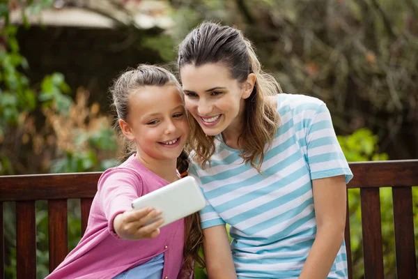 Smiling girl taking selfie with mother — Stock Photo, Image