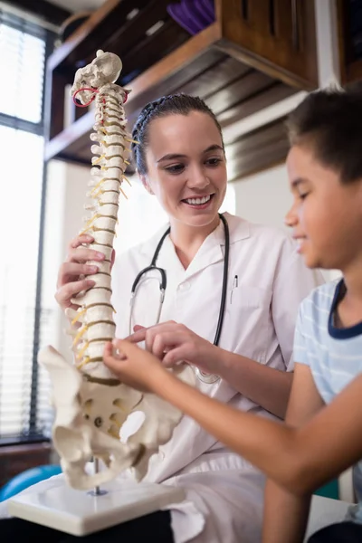 Therapist explaining boy with artificial spine — Stock Photo, Image