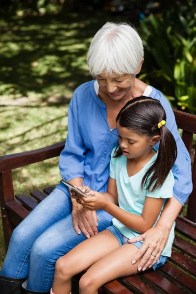 Granddaughter using mobile phone — Stock Photo, Image