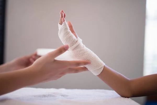 Terapeuta embrulho bandagem na mão — Fotografia de Stock