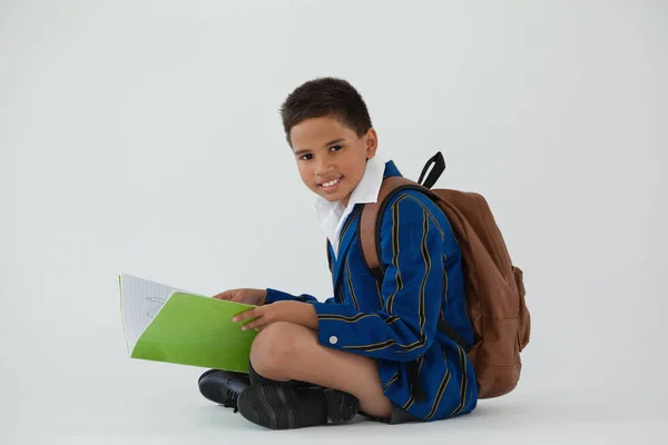 Colegial sentado y sosteniendo el libro —  Fotos de Stock