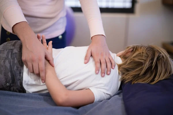 Therapeut untersucht Arm des Jungen — Stockfoto