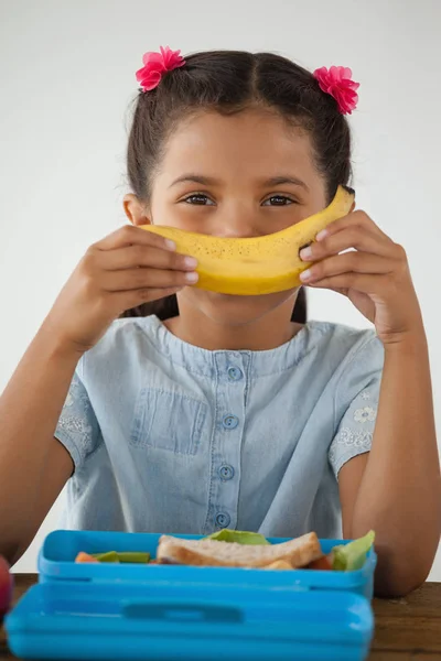 Uczennica jedzenie banana — Zdjęcie stockowe