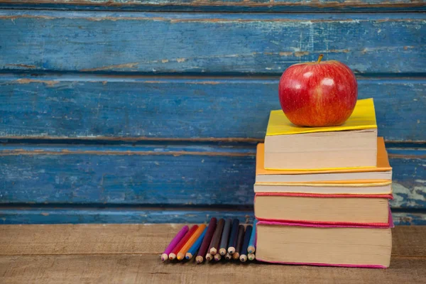 Libros apilados y manzana con lápices —  Fotos de Stock