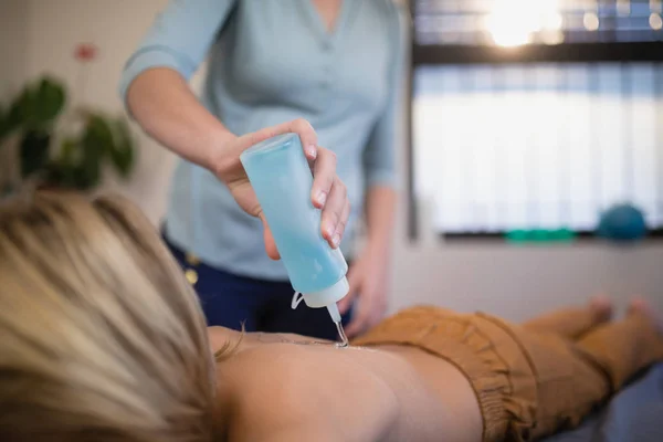 Therapist pouring ultrasound gel on boy — Stock Photo, Image