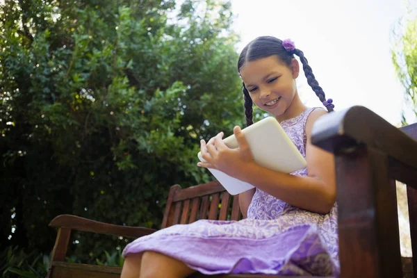 Dziewczyna przy użyciu cyfrowego tabletu na ławce — Zdjęcie stockowe