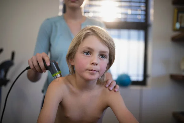 Niño sentado mientras terapeuta usando máquina de ultrasonido —  Fotos de Stock