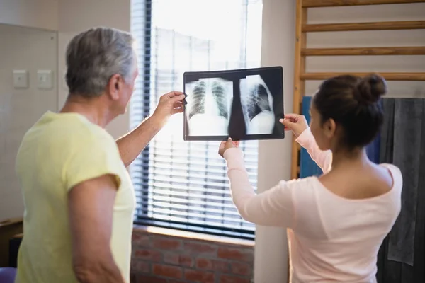 Patient and therapist looking at x-ray — Stock Photo, Image