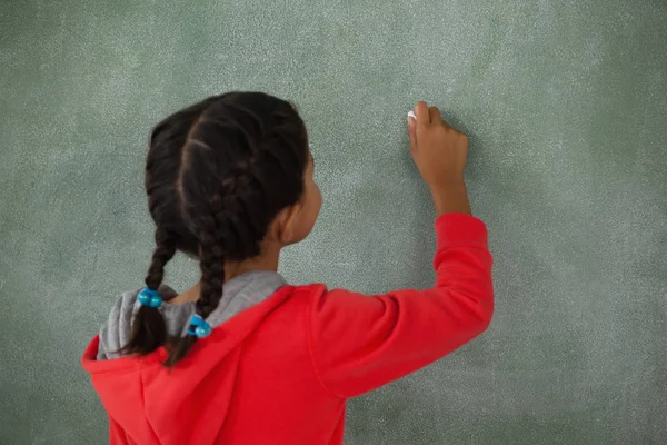 Jeune fille écriture sur tableau de craie — Photo