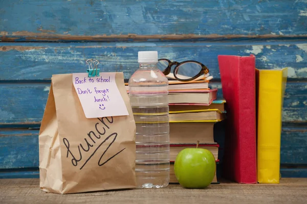 Libri impilati con mela e sacchetto pranzo — Foto Stock