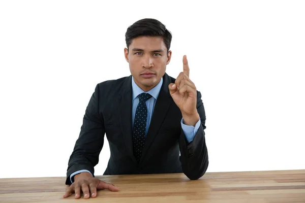 Businessman pointing upwards at table — Stock Photo, Image