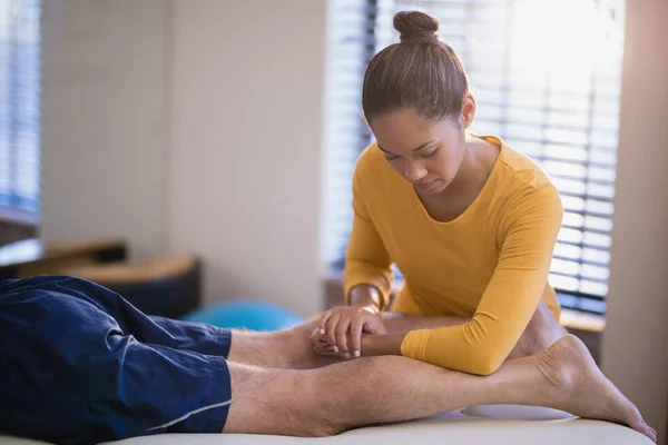 Terapeuta massageando bezerro do paciente — Fotografia de Stock