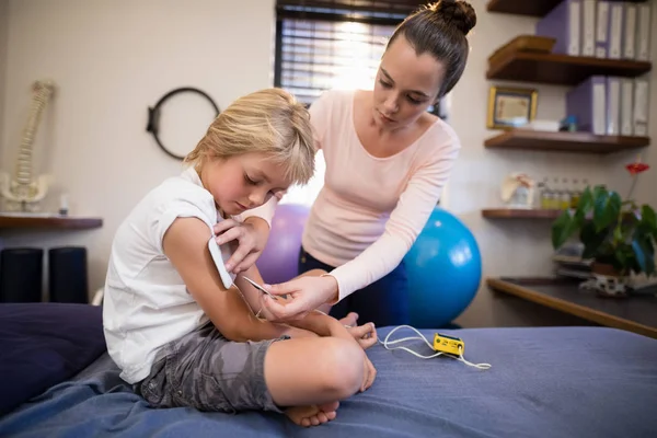 Elektródok elhelyezése a fiú karját terapeuta — Stock Fotó