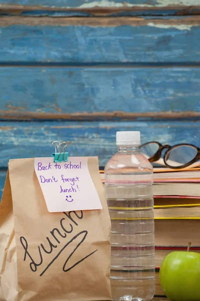 Libri impilati con mela e sacchetto pranzo — Foto Stock