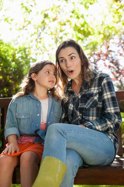 Girl whispering in ears of surprised mother — Stock Photo, Image