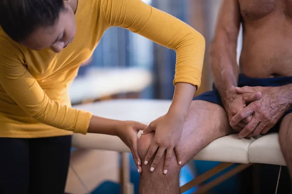 Terapeut masážními koleno pacienta — Stock fotografie