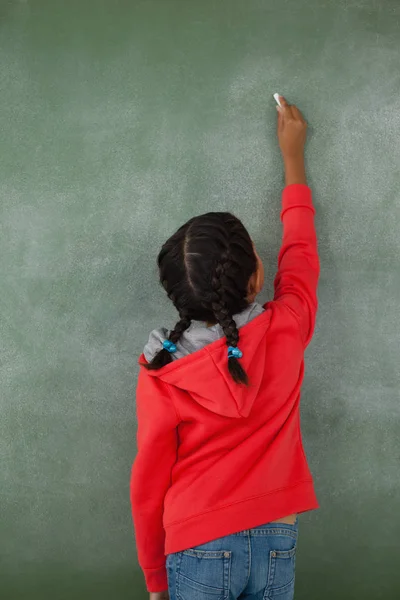 Jeune fille écriture sur tableau de craie — Photo