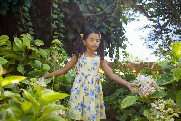 Mädchen steht inmitten grüner Pflanzen — Stockfoto
