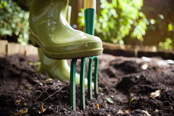 Woman standing with fork on dirt — Stock Photo, Image