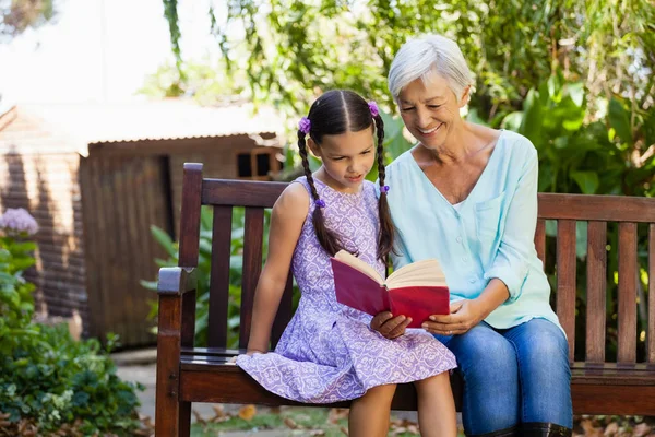 Grand-mère lecture livre à petite-fille — Photo