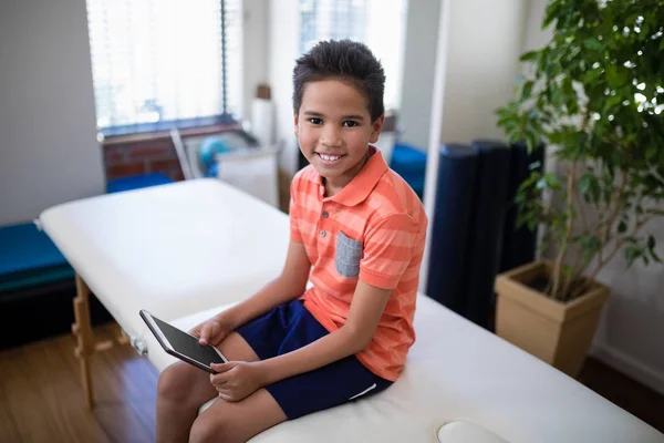 Fiú ül az ágyon, digitális tabletta — Stock Fotó