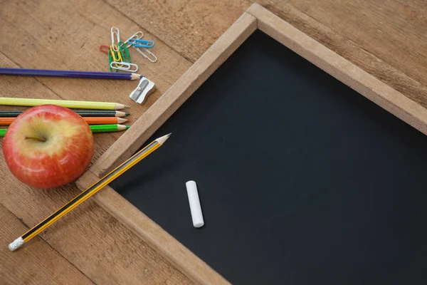 Školní potřeby s břidlice a apple — Stock fotografie