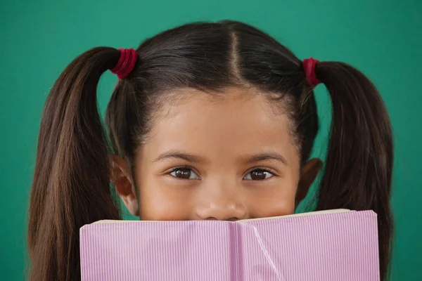 Schoolgirl hiding book — Stock Photo, Image