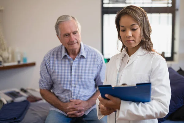 Patient and therapist looking at file — Stock Photo, Image