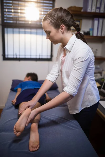 Terapeuta examinando perna com menino — Fotografia de Stock