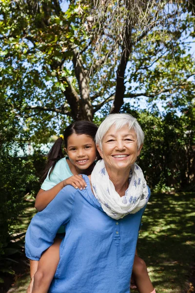 Mormor ger piggyback till barnbarn — Stockfoto