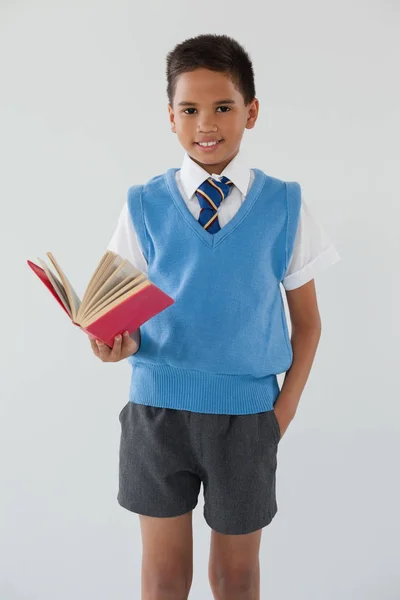 Schoolboy de pé com livro — Fotografia de Stock