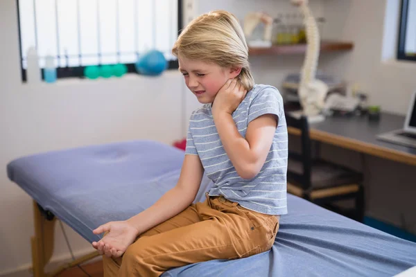 Chlapce, který seděl na posteli s bolest krku — Stock fotografie