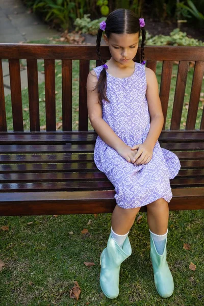 Boos meisje zittend op houten bankje — Stockfoto