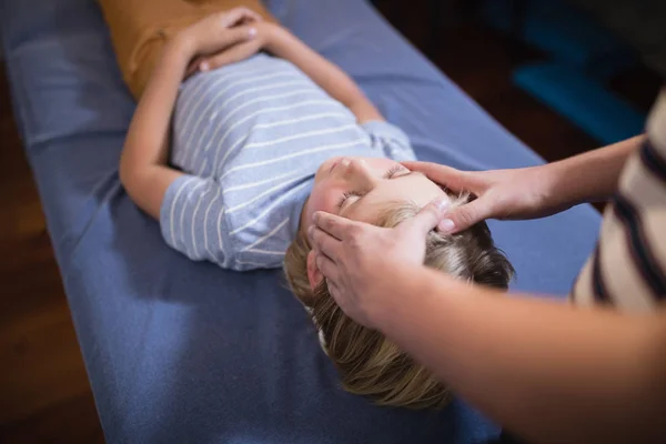 Terapeuta dando masaje de cabeza a chico — Foto de Stock