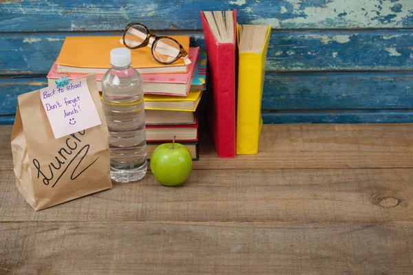 Elma ve öğle yemeği çanta ile yığılmış kitaplar — Stok fotoğraf
