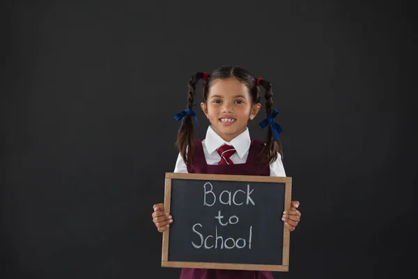 Colegiala sosteniendo pizarra con texto —  Fotos de Stock