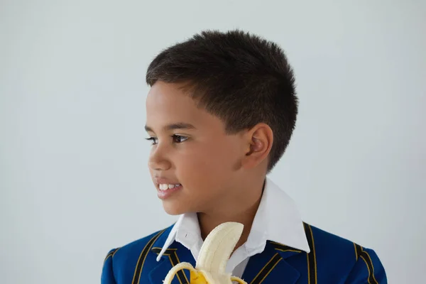 Schoolboy having banana — Stock Photo, Image