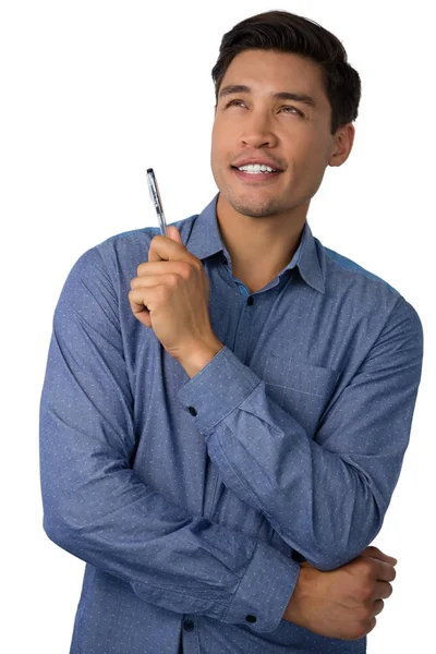 Hombre de negocios sosteniendo la pluma mientras mira hacia otro lado — Foto de Stock