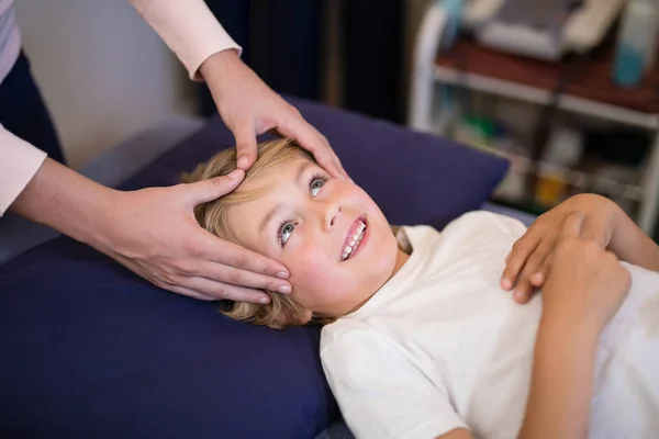 Терапевт дає масаж голови хлопчикові — стокове фото