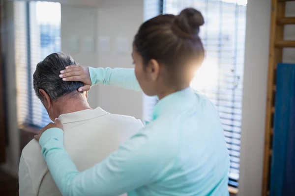 Terapeuta dando masaje en el cuello al paciente — Foto de Stock