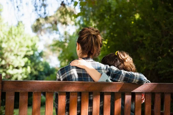 Moeder en dochter zitten met armen rond — Stockfoto