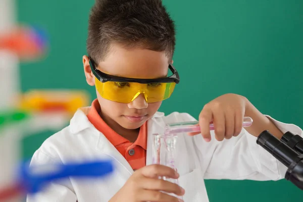 Schoolboy experimenting in laboratory — Stock Photo, Image