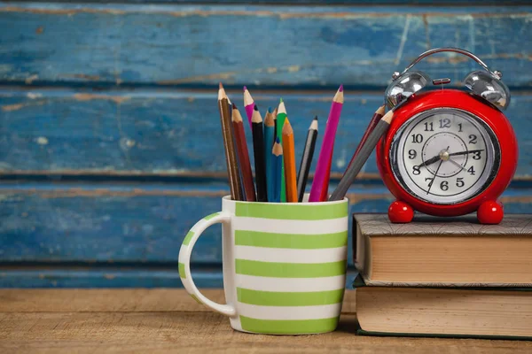 Reloj despertador con libros y porta bolígrafos —  Fotos de Stock