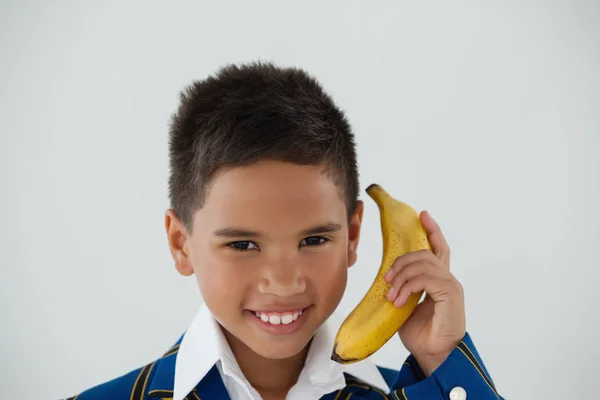 Colegial sosteniendo plátano — Foto de Stock