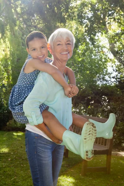 Großmutter huckepack Enkelin — Stockfoto