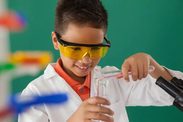 Schoolboy experimenting in laboratory — Stock Photo, Image